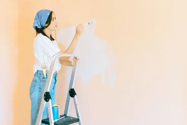 Interior painting in Sioux Falls: painter on a stepladder rolling a wall